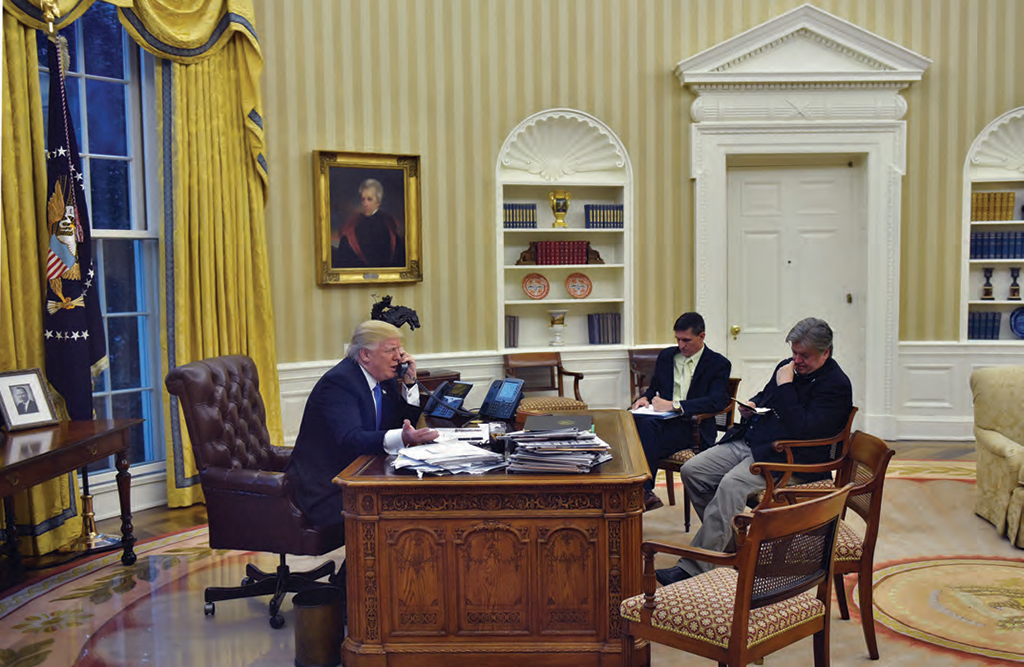 Trump speaking on the phone in the Oval Office, alongside Chief Strategist Steve Bannon and former National Security Advisor Michael Flynn. AFP PHOTO / MANDEL NGAN