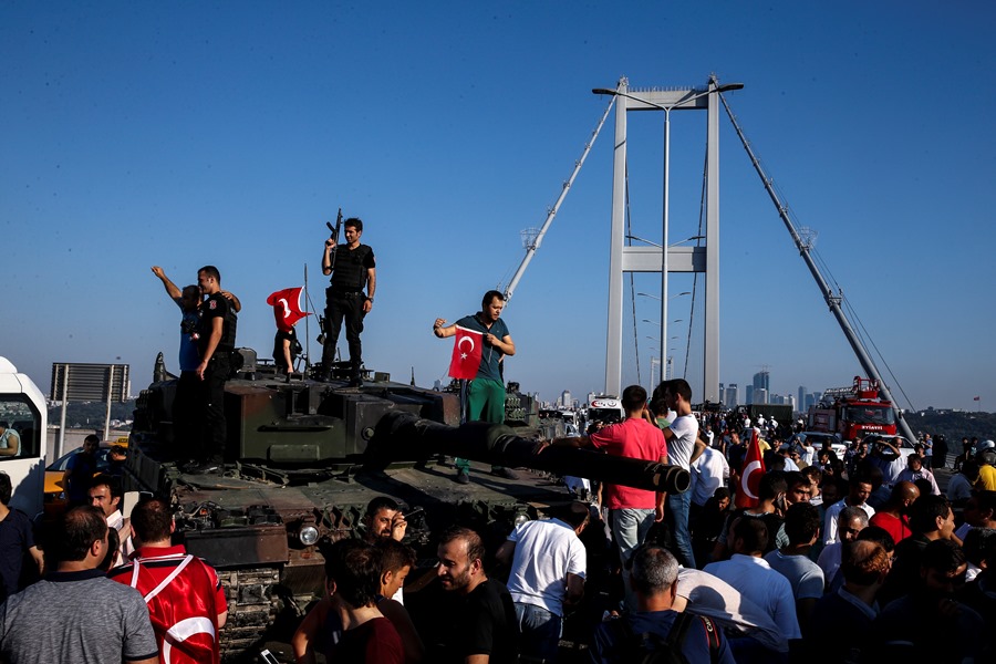 Police officers, together with a large crowd, take over a tank after the surrender of the last remaining coup plotters in the morning of July 16, Bosporus Bridge.  AA PHOTO /  ARİF HÜDAVERDİ YAMAN