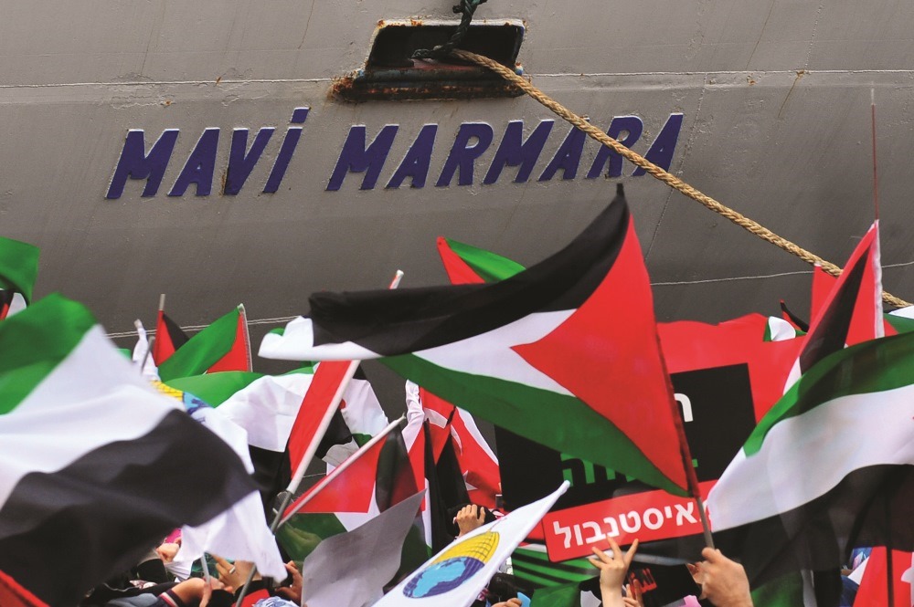 Turkish ship Mavi Marmara arrives at Istanbul’s Sarayburnu port  as people wave Turkish and Palestinian flags  on December 26, 2010. The Israeli navy raided on  May 31, 2010 the Turkish ship Mavi Marmara. AFP / Mustafa Özer